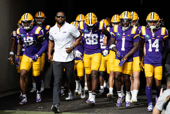 Jan 1, 2024; Tampa, FL, USA; LSU Tigers wide receivers coach Cortez Hankton, tight end Ka'Morreun Pimpton (88), and wide receiver Aaron Anderson (1) run onto the field before the game against the Wisconsin Badgers at Raymond James Stadium.